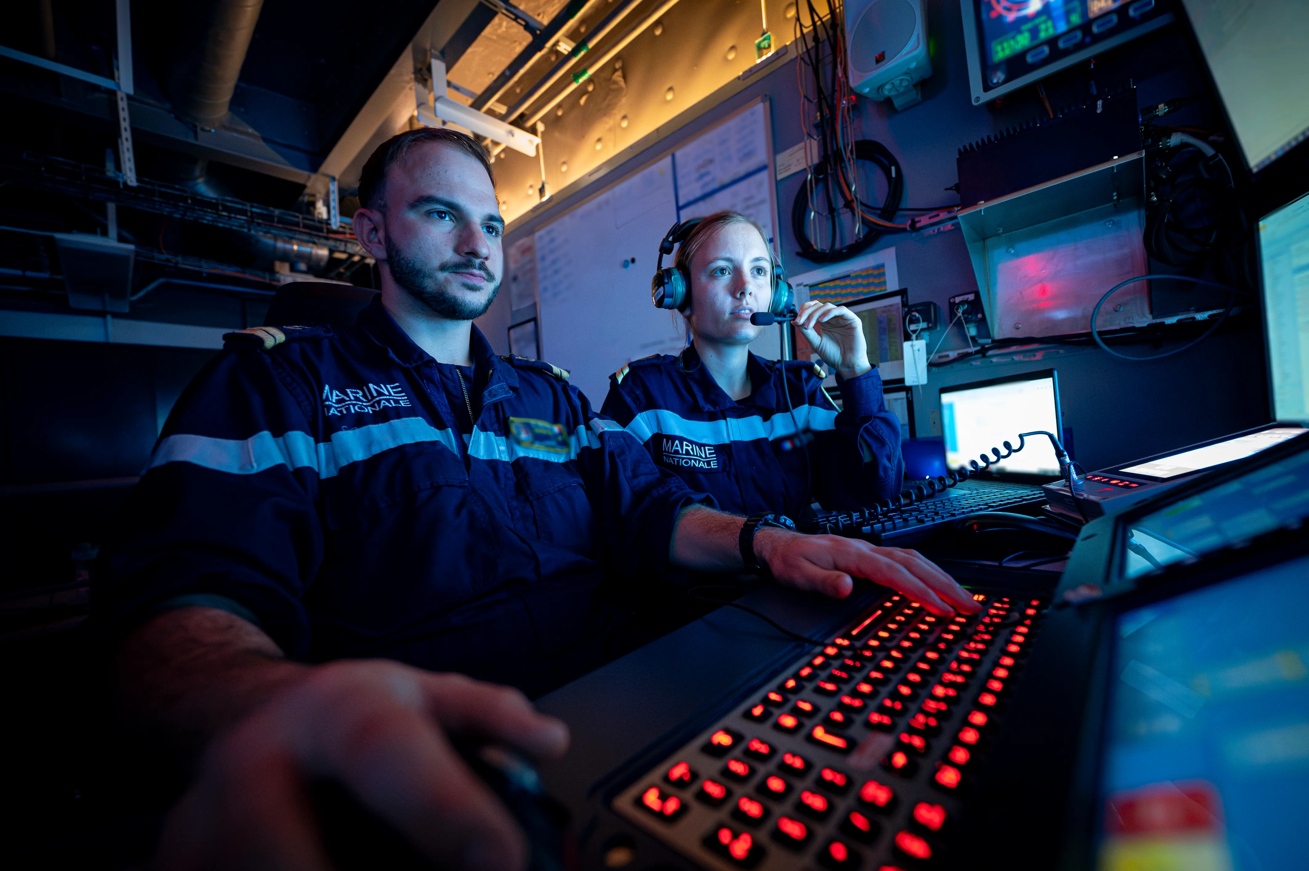 Equipe de marins spécialisés dans la conduite et maintenance nucléaire en train de regarder un écran de contrôle