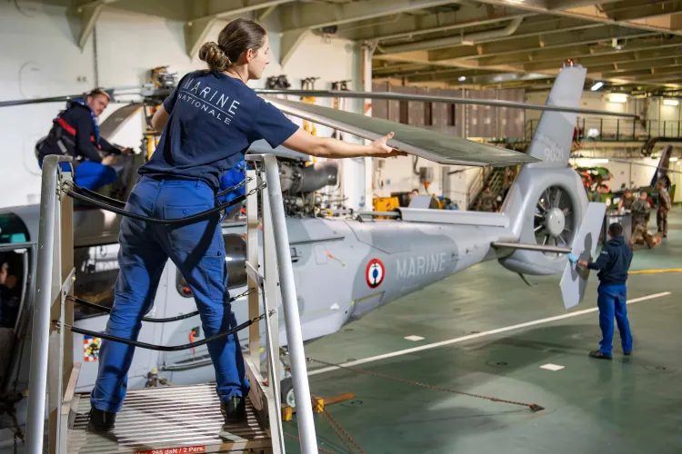 Techniciens de l'aéronautique navale réparant un hélicoptère