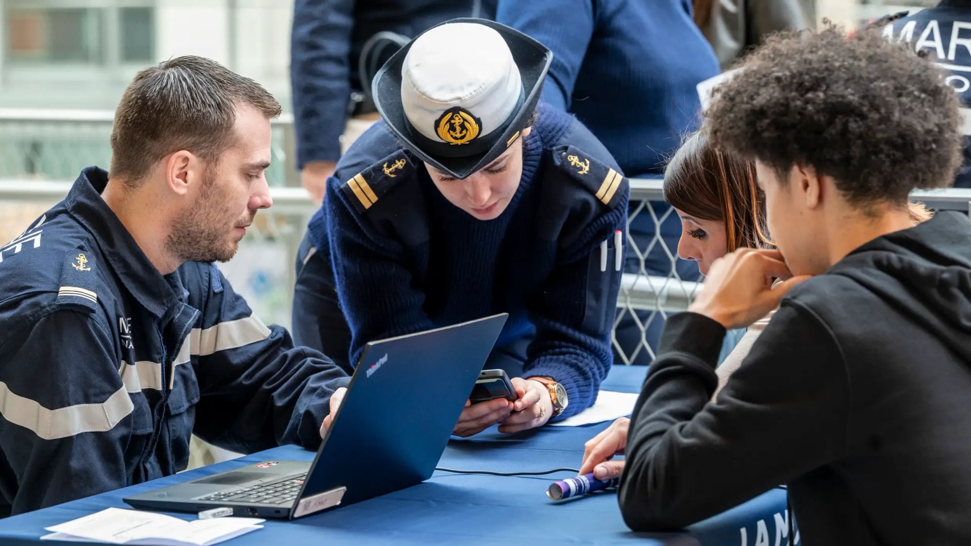Deux marins conseillers en recrutement en entretien avec un jeune et sa mère pour faire découvrir les possibilités qu'offre la marine