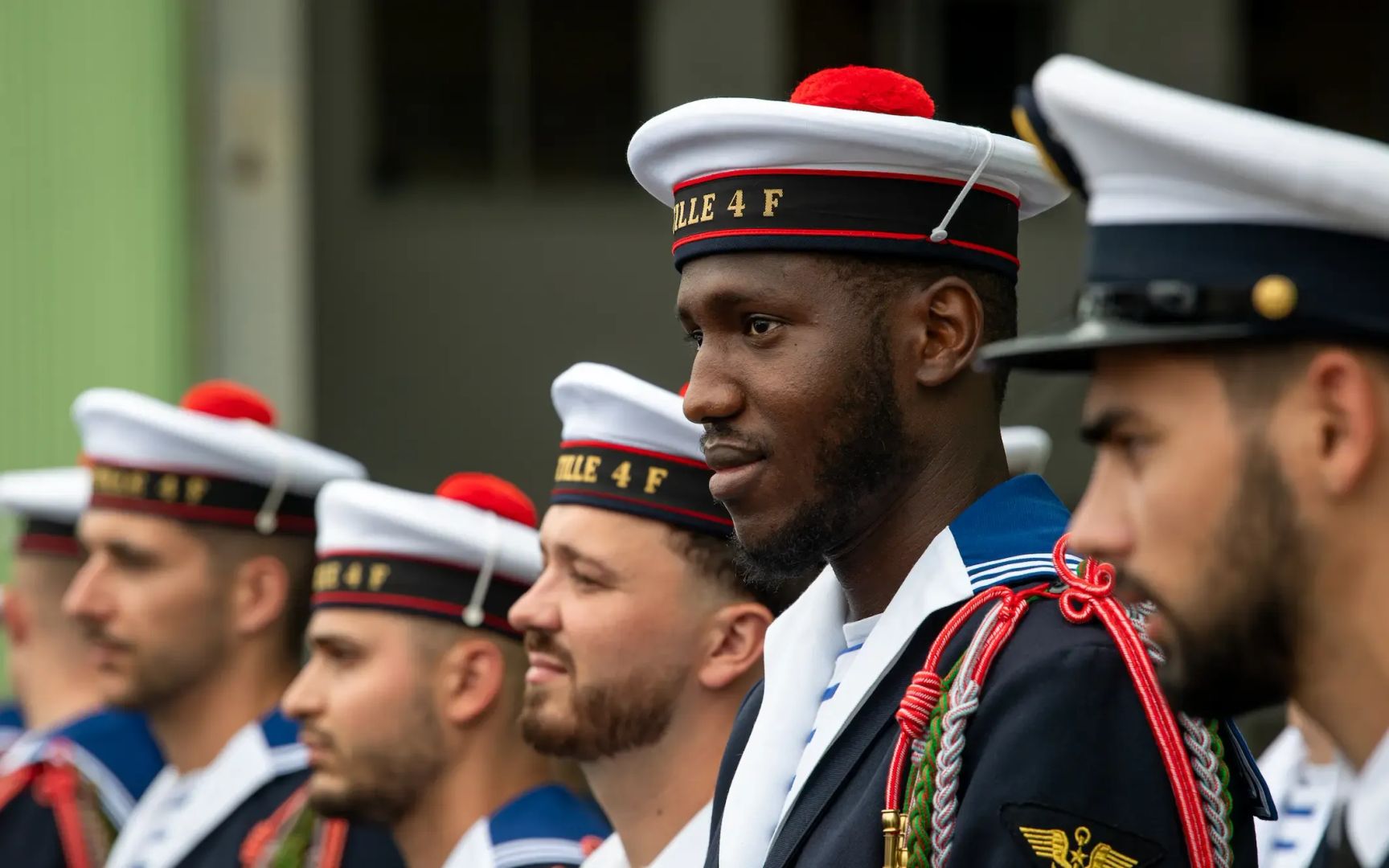 Des matelots en uniforme de cérémonie recevant des décorations.
