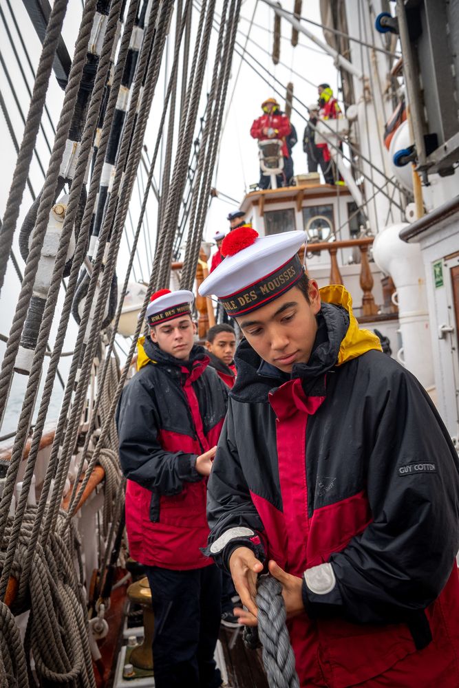 Jeunes mousses tirant sur une corde sur une embarcation