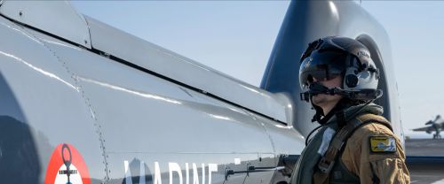 Un personnel naviguant tactique fait face à un hélicoptère de la Marine Nationale
