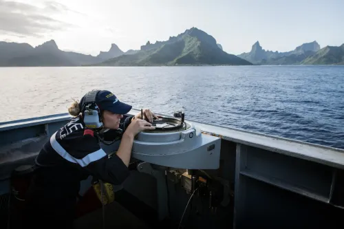 Une femme marin utilisant un compas de navigation pour établir la route de navigable