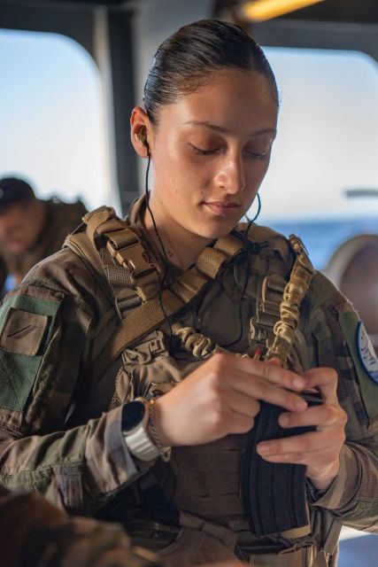 Une fusilier marin, en treillis, en train de vérifier son équipement avant de partir en mission.