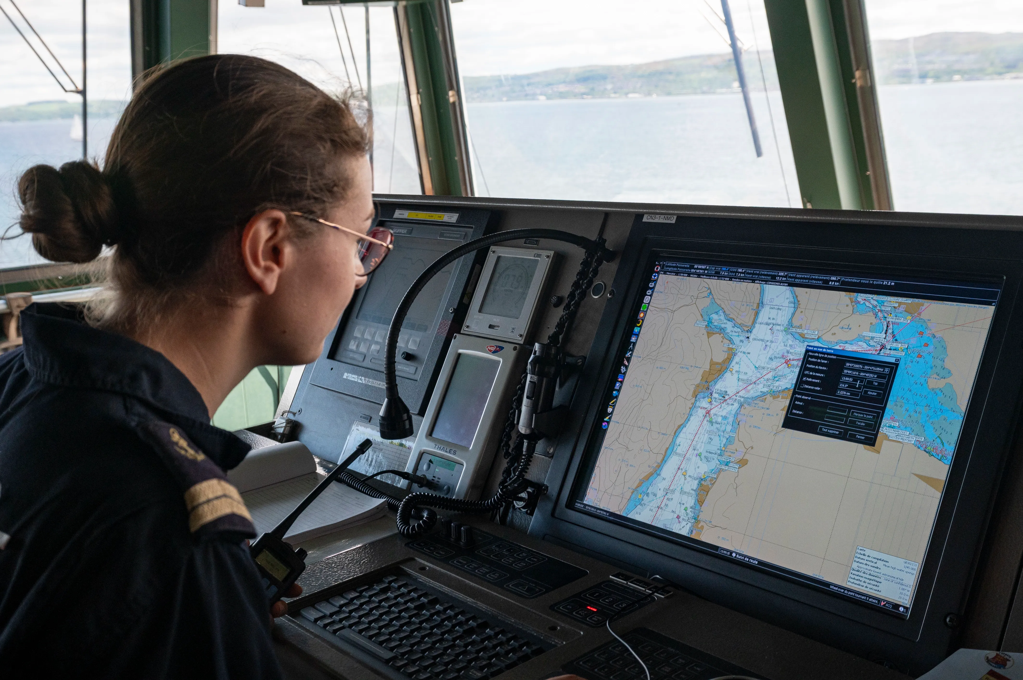 Marin consultant une carte numérique de navigation afin de contrôler la direction du navire