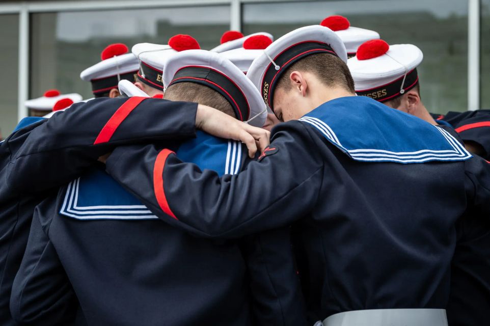 Un groupe de mousse formant un cercle, se tenant par les épaules, pour se motiver tous ensemble.