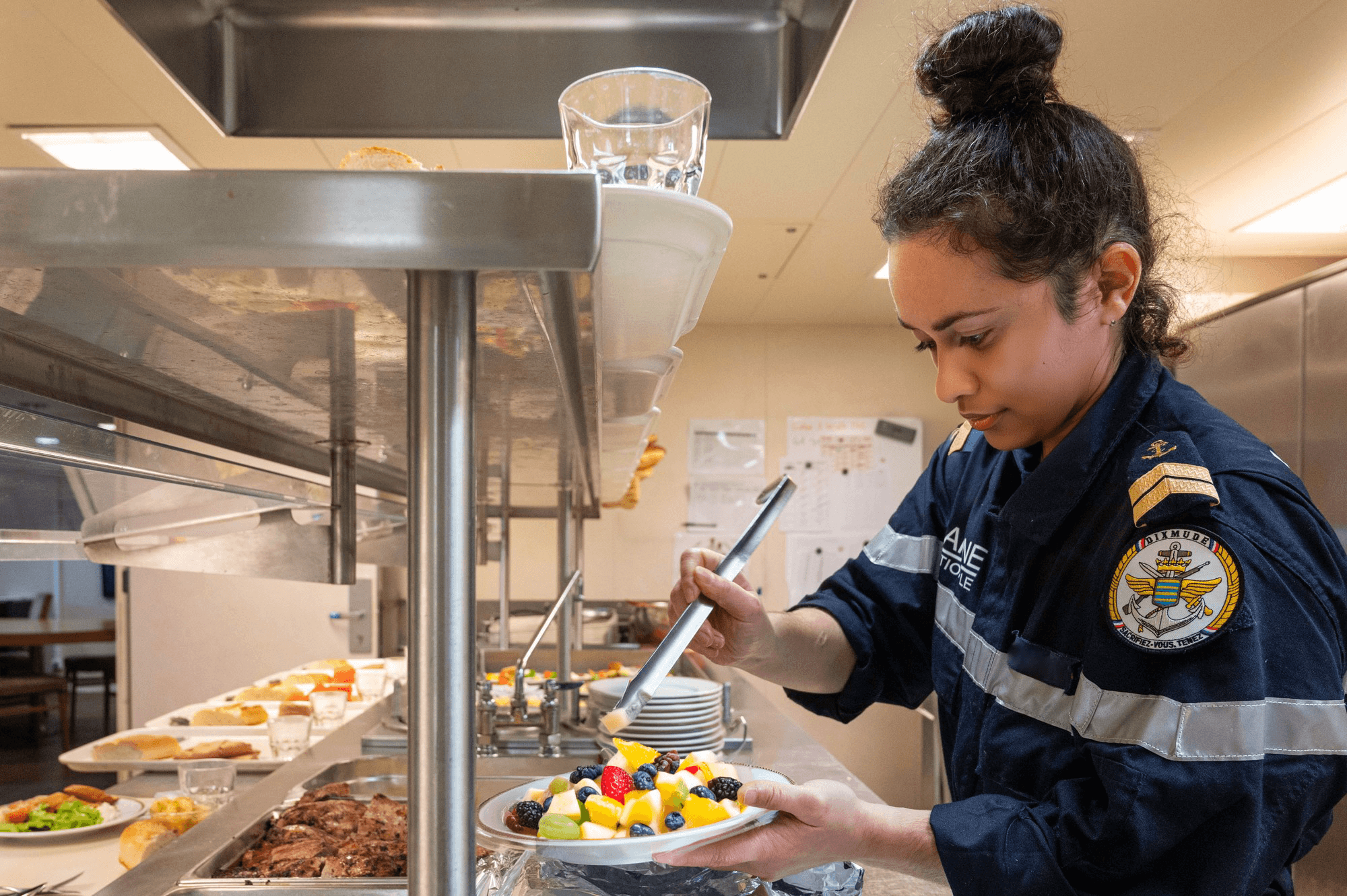 Marine de la Marine Nationale se servant de la nourriture