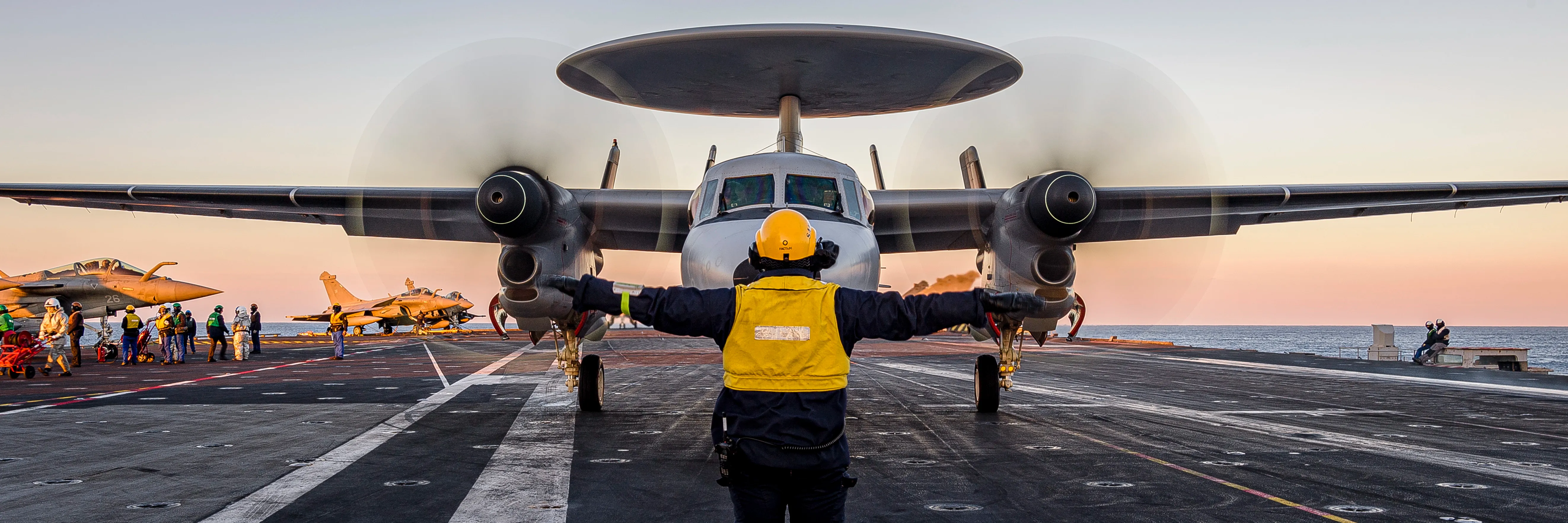 Operateur de manutention des aéronefs fait atterrir un avion de la Marine Nationale