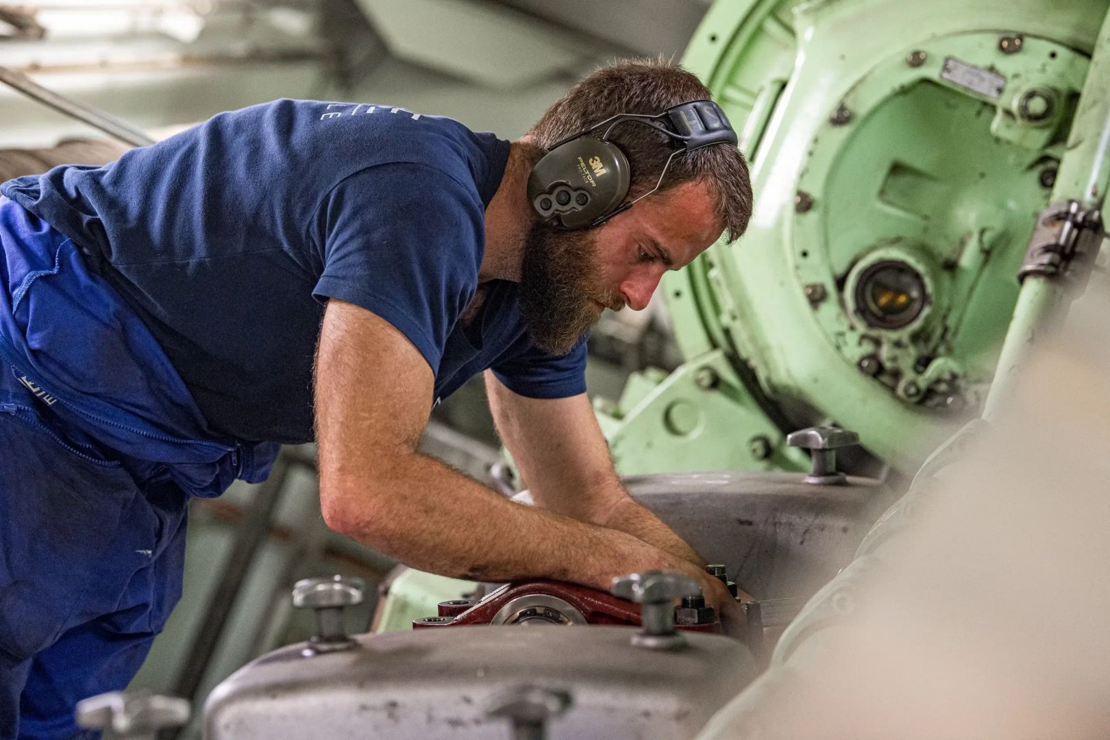 un électromécanicien travaillant sur les machines d'un navire de la Marine nationale.
