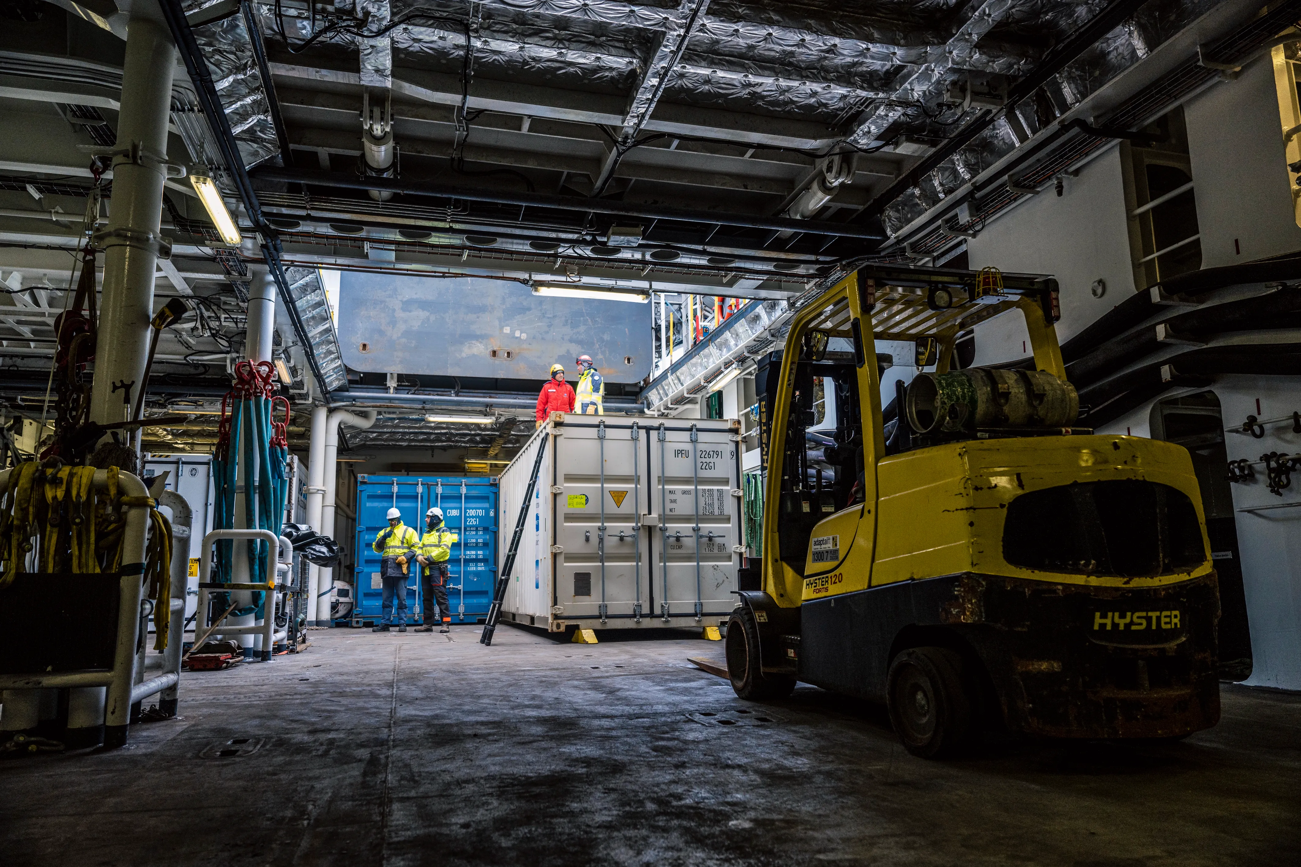 Un hangar de stockage d'un navire de la Marine nationale, avec un véhicule transpalette