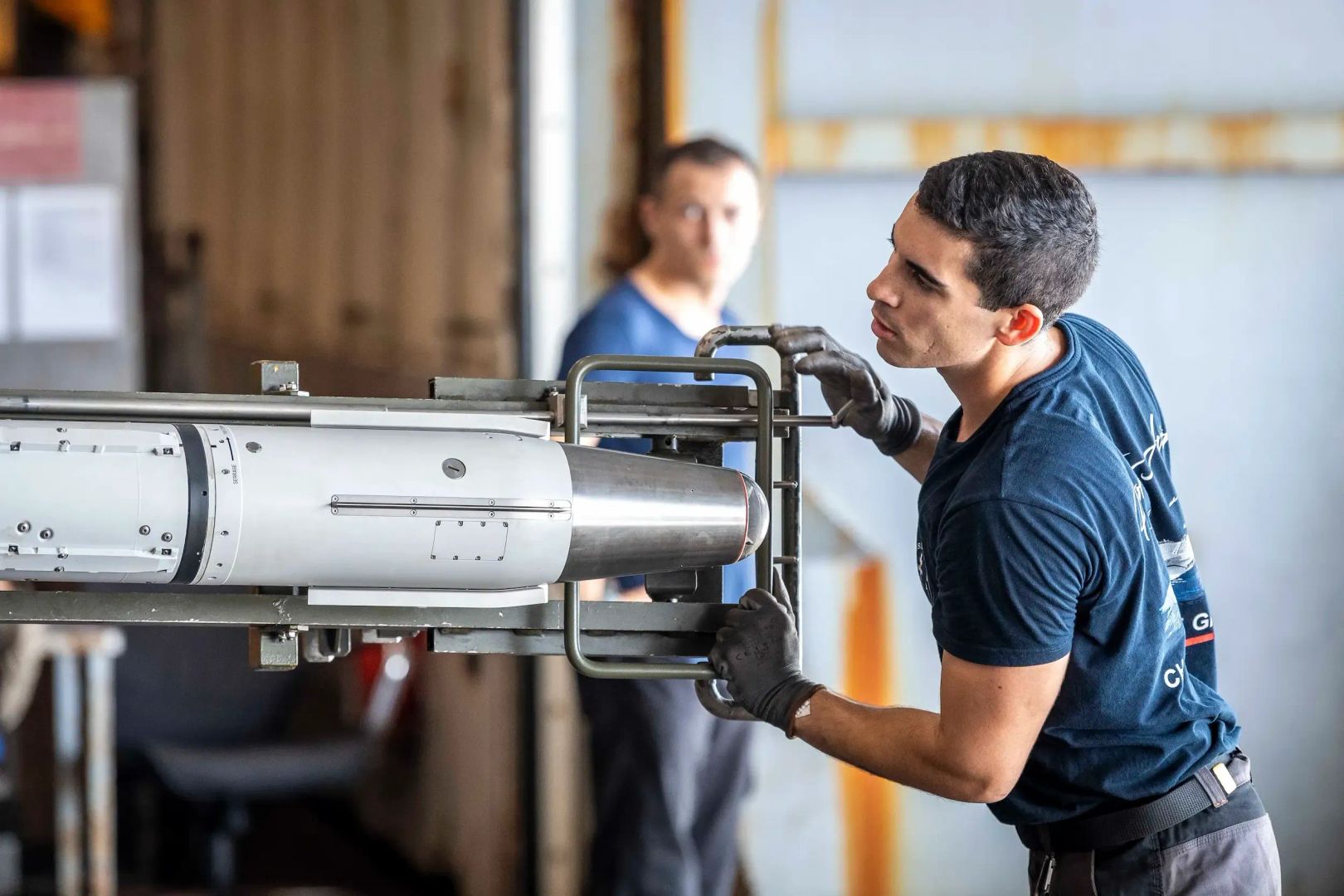 Un technicien aéronautique de l'armement en train de réviser l'armement d'un aéronef de la marine nationale.