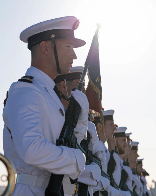 Une cérémonie de la marine nationale, les uniformes de cérémonies sont blancs, les marins sont alignés en rang.