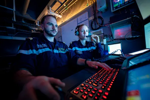 Equipe de marins spécialisés dans la conduite et maintenance nucléaire en train de regarder un écran de contrôle
