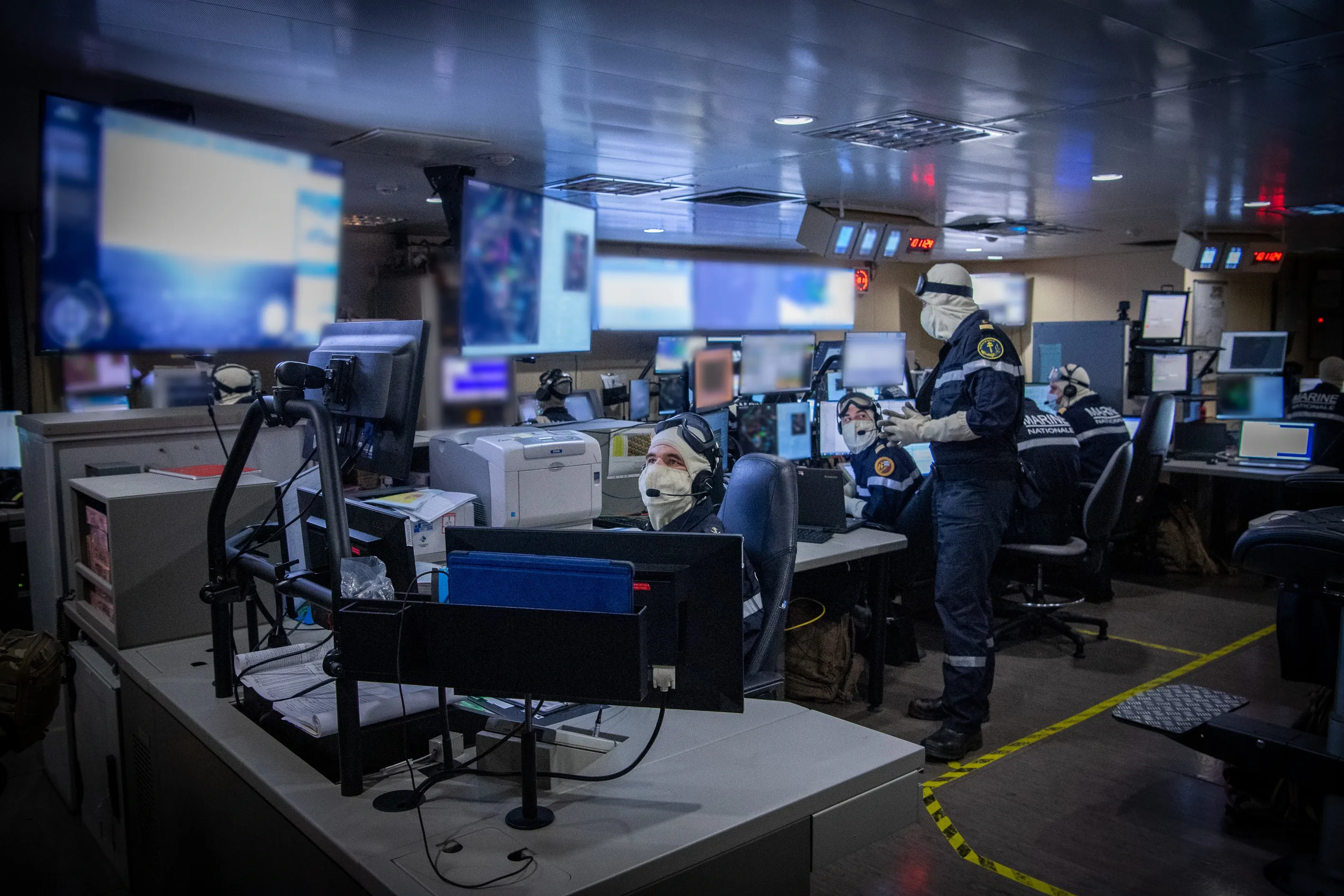 Des bureaux de renseignement de la marine nationale remplis d'ordinateurs et d'écrans.