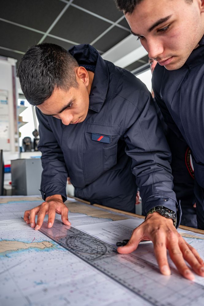 Deux matelots de l'école des matelots travaillent sur une carte
