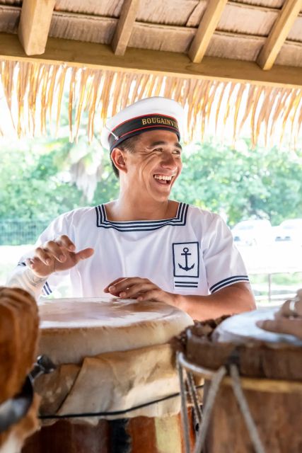Un matelot polynésien en uniforme en train de jouer d'un instrument de musique.