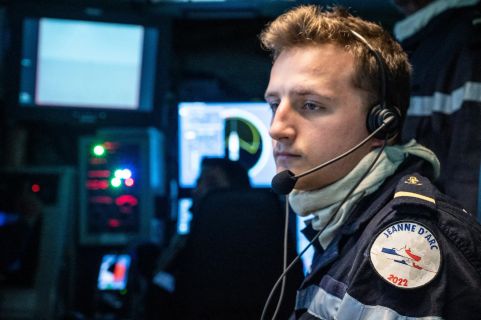 Un jeune officier de spécialité informatique concentré et travaillant à son poste de travail.