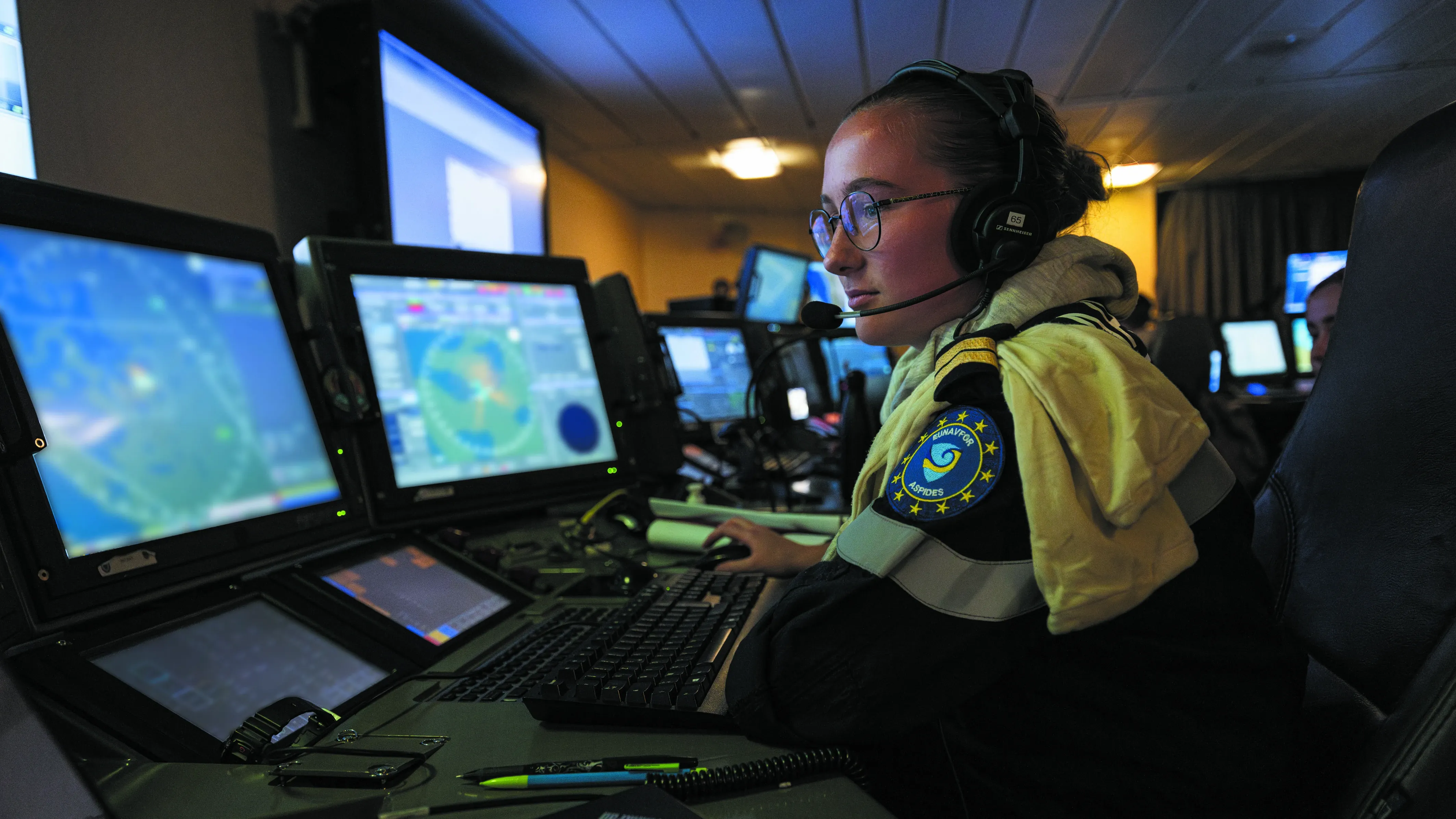 Une femme de la marine nationale, section renseignement, à poste sur des écrans de contrôles