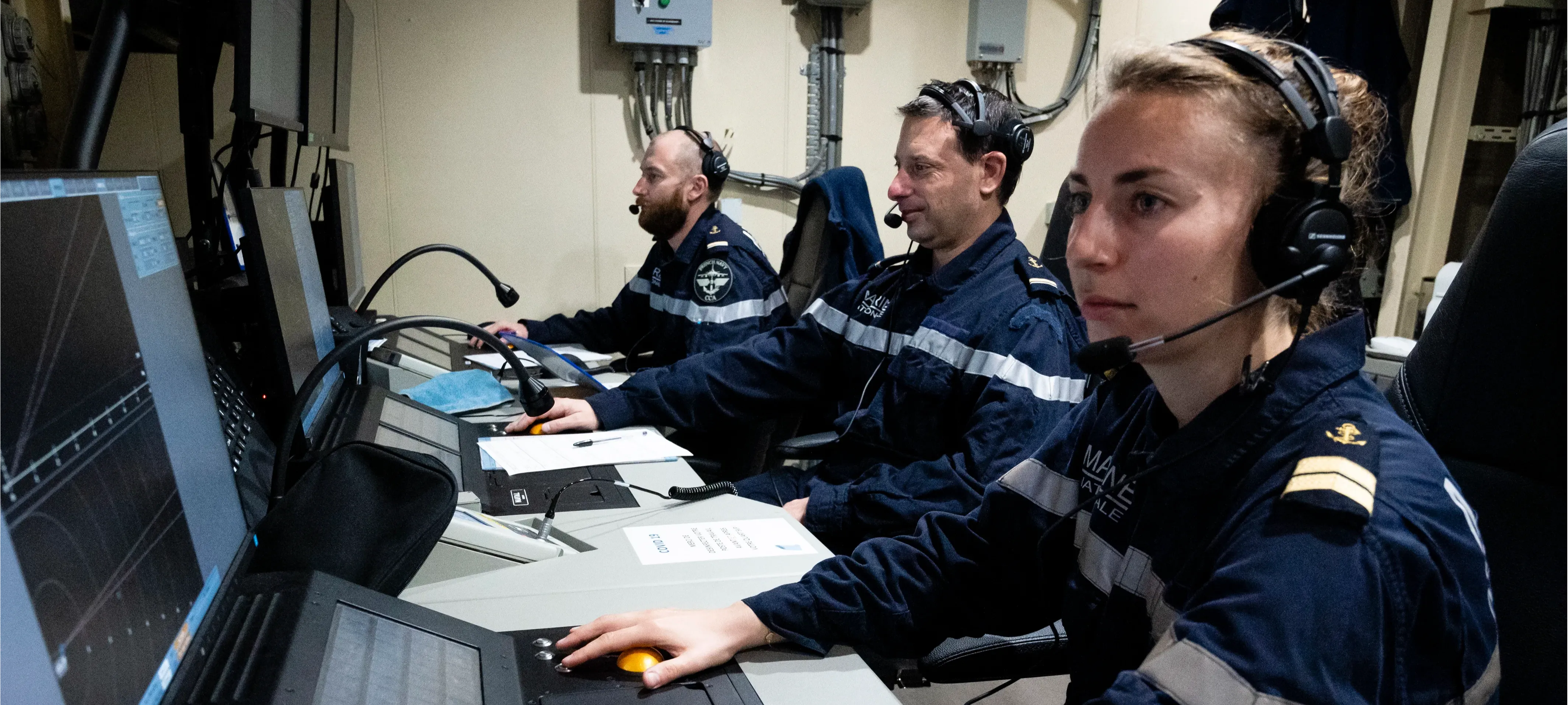 Des contrôleurs aériens de la Marine Nationale écoutent attentivement