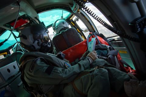 un tacae, responsable tactique de l'aéronautique, en tenue de vol et dans le cockpit d'un hélicoptère.