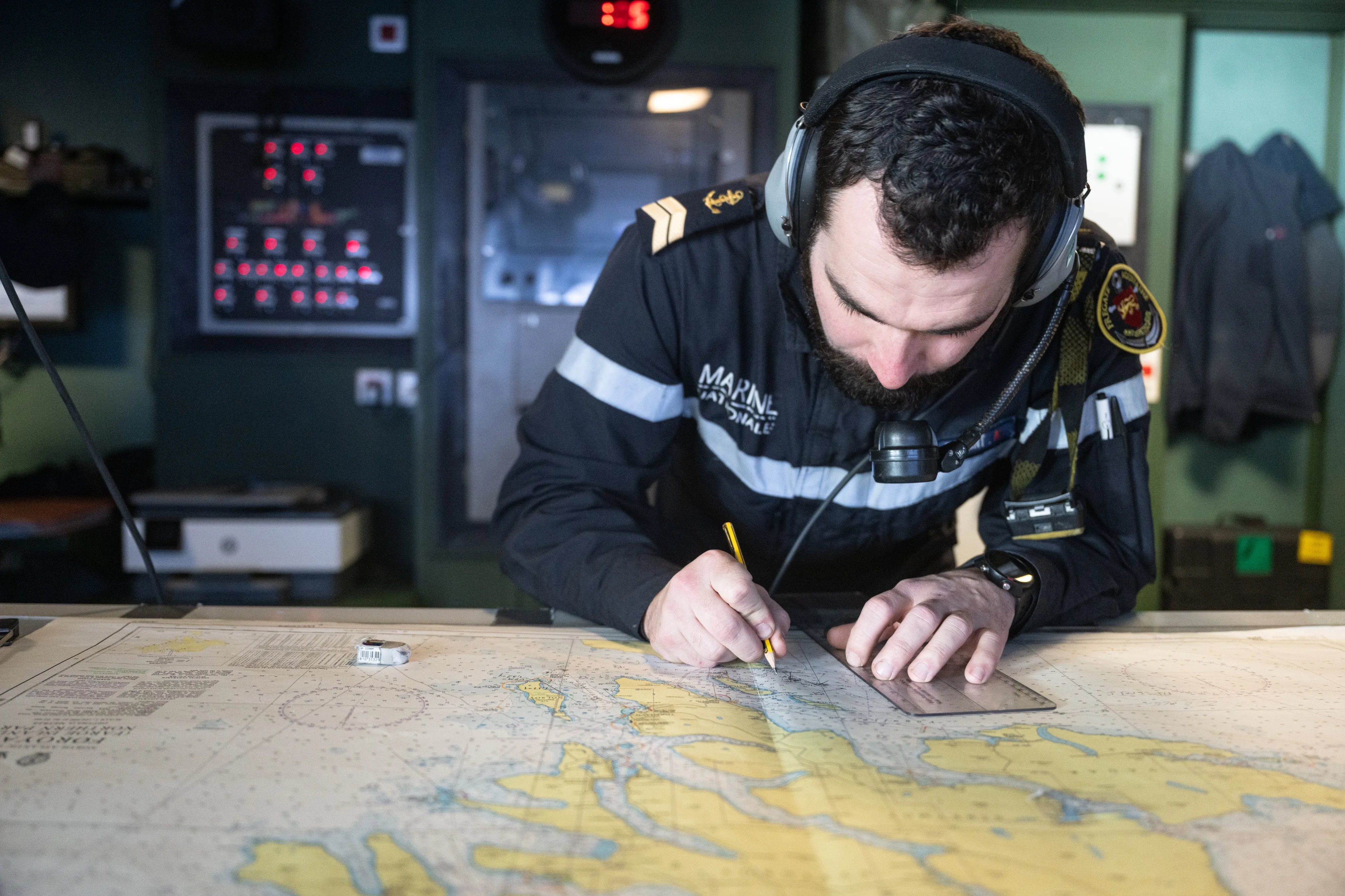 Marin en train de mettre à jour une carte de navigation