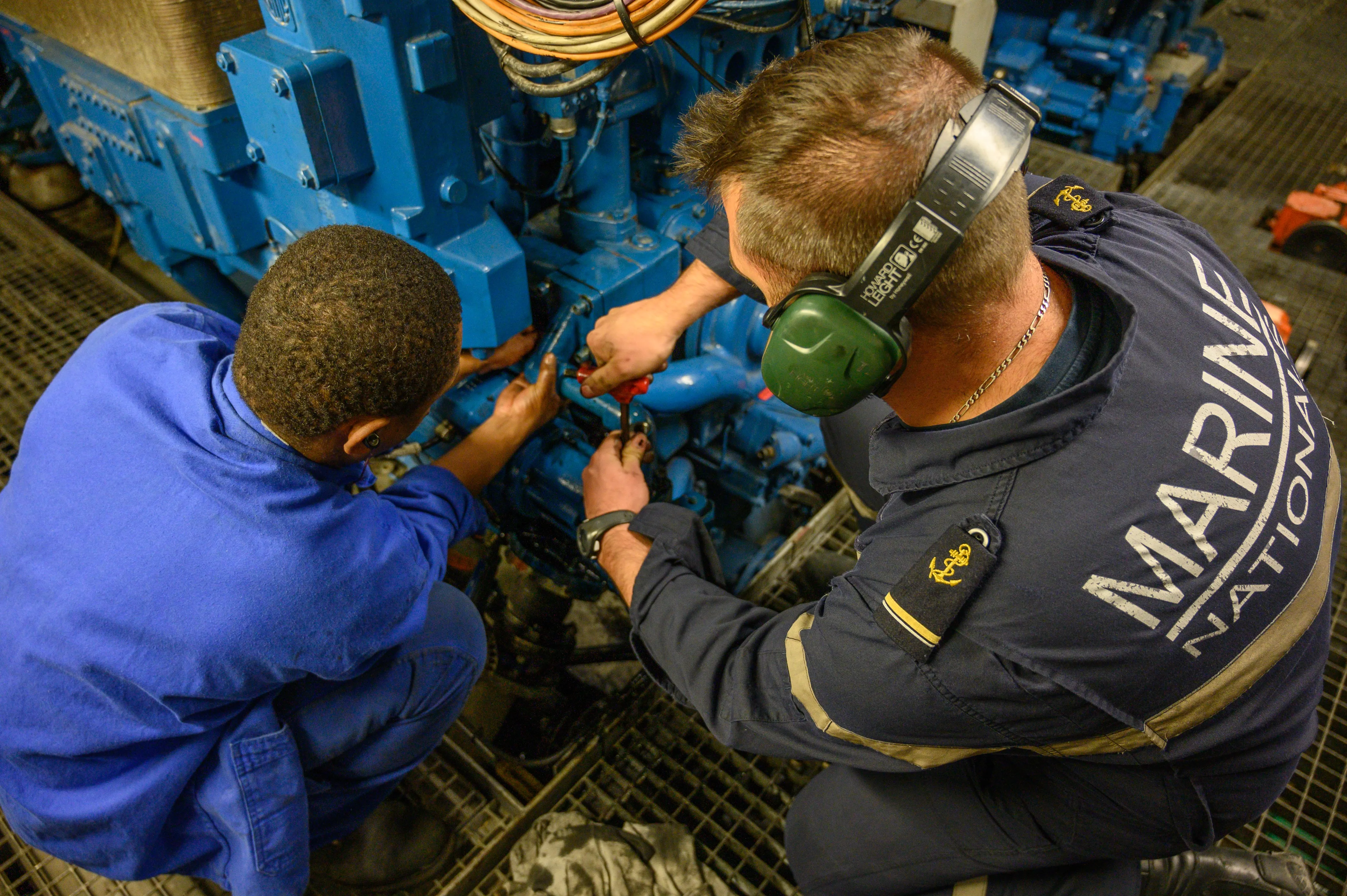 Des mécaniciens navals de la marine nationale en train de travailler sur des machineries d'un navire