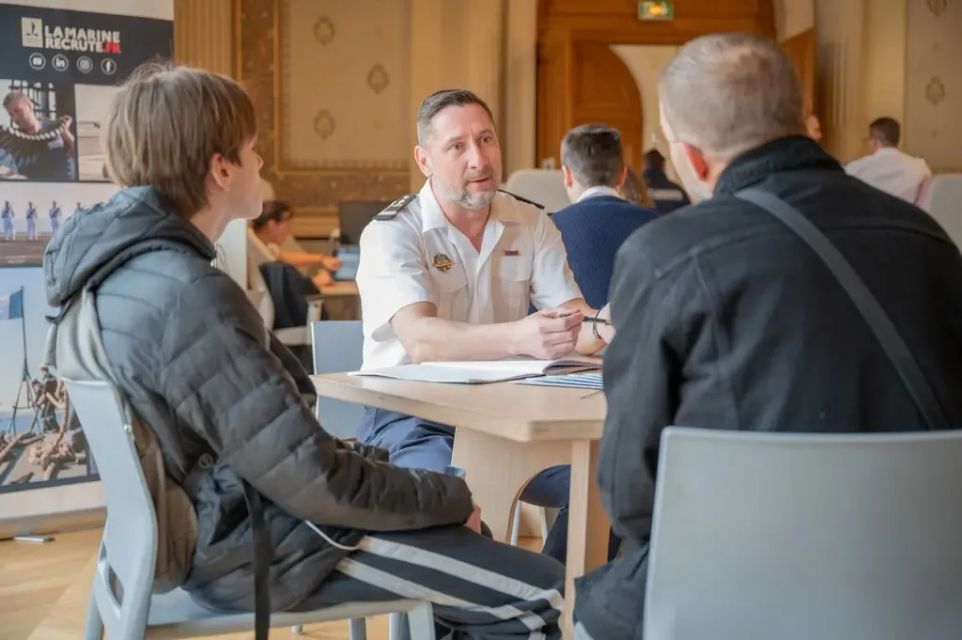 Un conseiller en recrutement marin en entretien de découverte avec un jeune et son père
