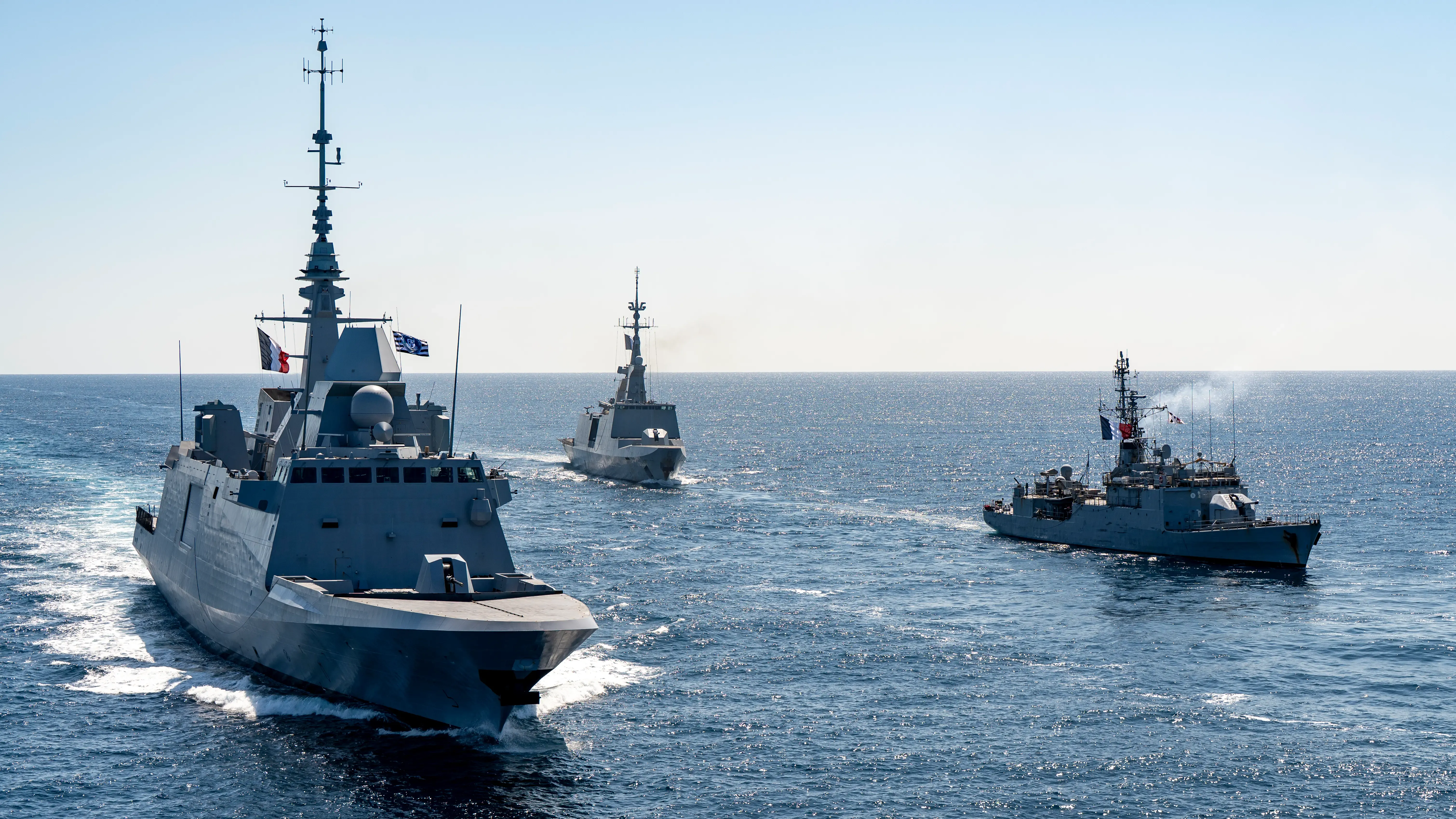 Trois frégates de la marine nationale française en formation de combat, naviguant sur une mère calme