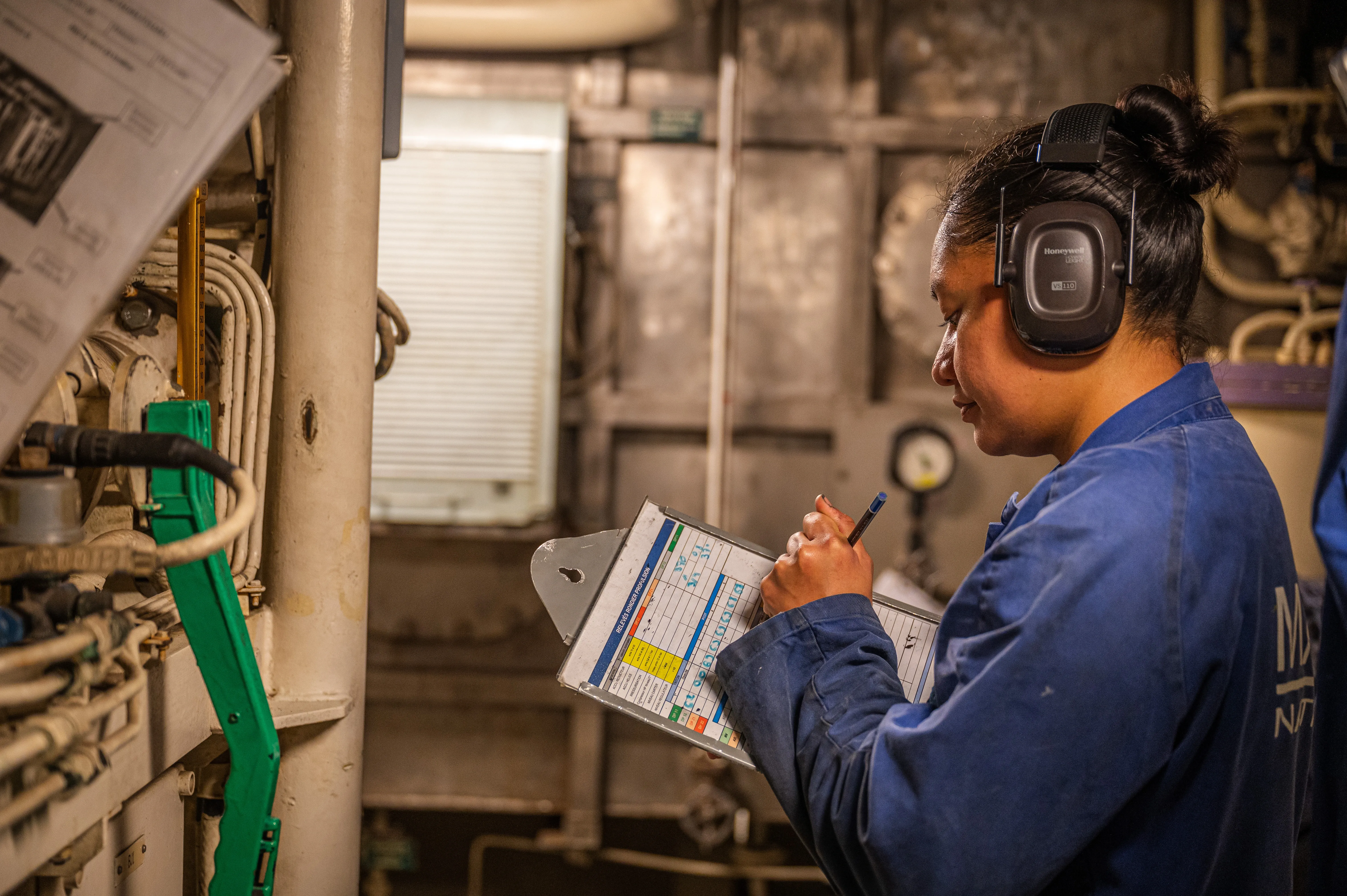 Une technicienne de conduite et maintenance nucléaire en train de relever des données et informations cruciales pour la maintenance