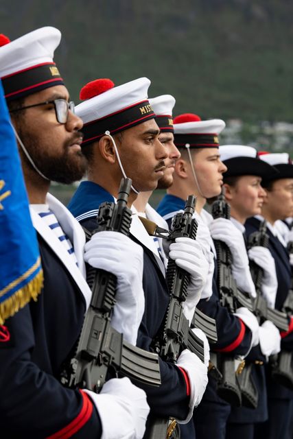 Des matelots en uniformes de cérémonie, alignés en rang avec des armes de cérémonies