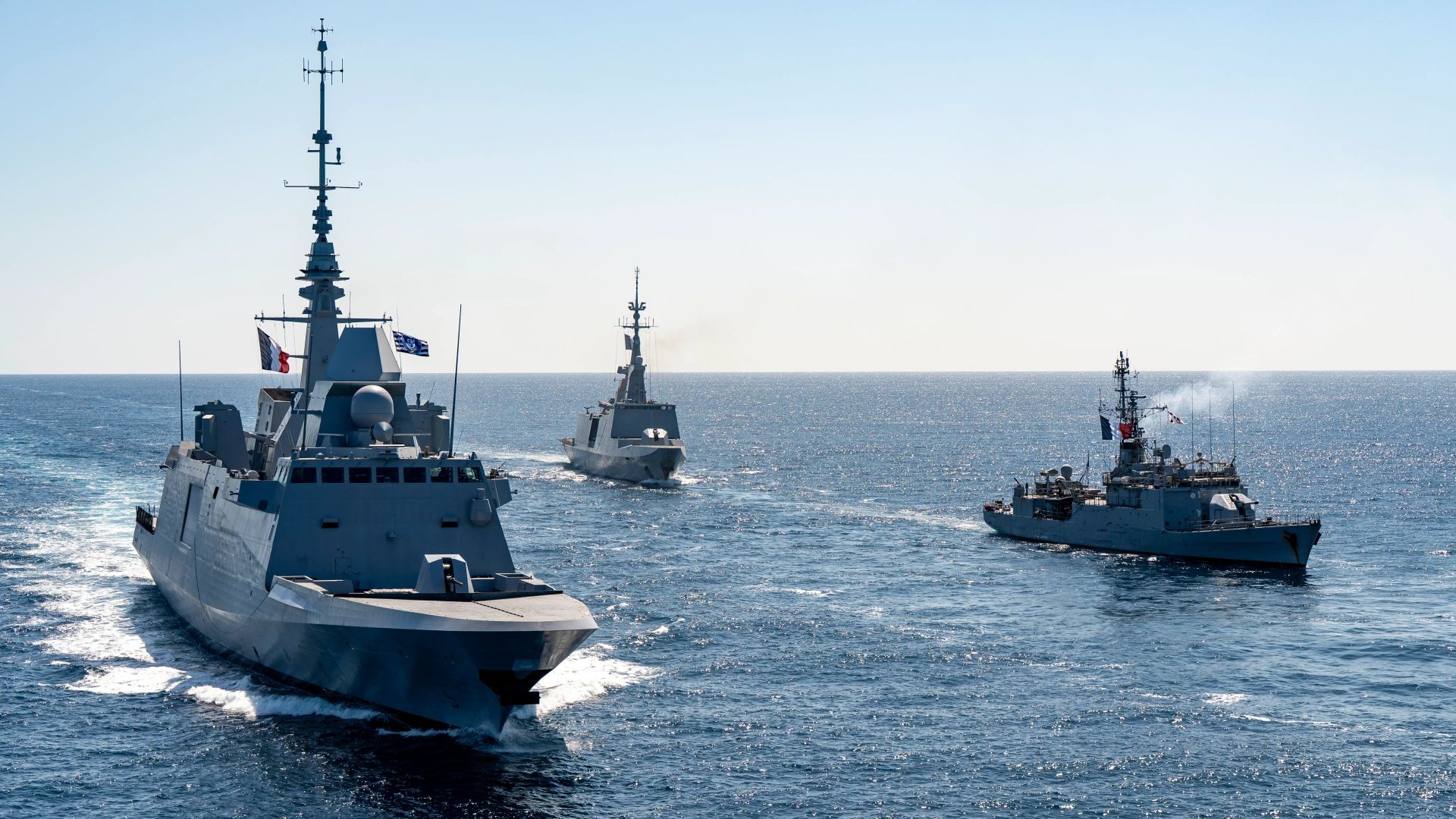 Trois frégates de la marine nationale française en formation de combat, naviguant sur une mère calme