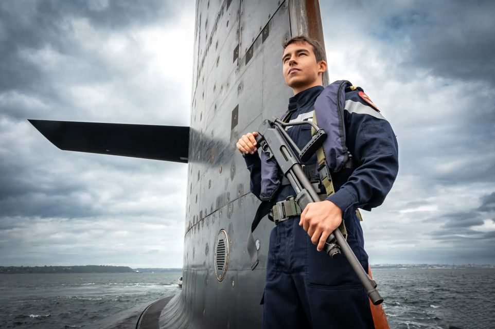 un second-maitre sous-marinier montant la garde avec son arme de service sur un sous-marin.
